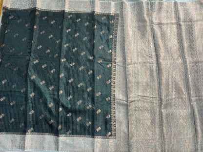 ಕಪ್ಪು ಹಸಿರು ಬಣ್ಣದ ಬನಾರಸಿ ರಷ್ಯನ್ ರೇಷ್ಮೆ ಸೀರೆ, ಚೆಕ್ಕರ್ ಮಾದರಿಯಲ್ಲಿ, ಸಣ್ಣ ಹೂವಿನ ಬುಟ್ಟಾ ಜೊತೆಗೆ ಕಾಂಟ್ರಾಸ್ಟ್ ಬಾರ್ಡರ್ - ಸಾಂಪ್ರದಾಯಿಕ ಉಡುಗೆ.