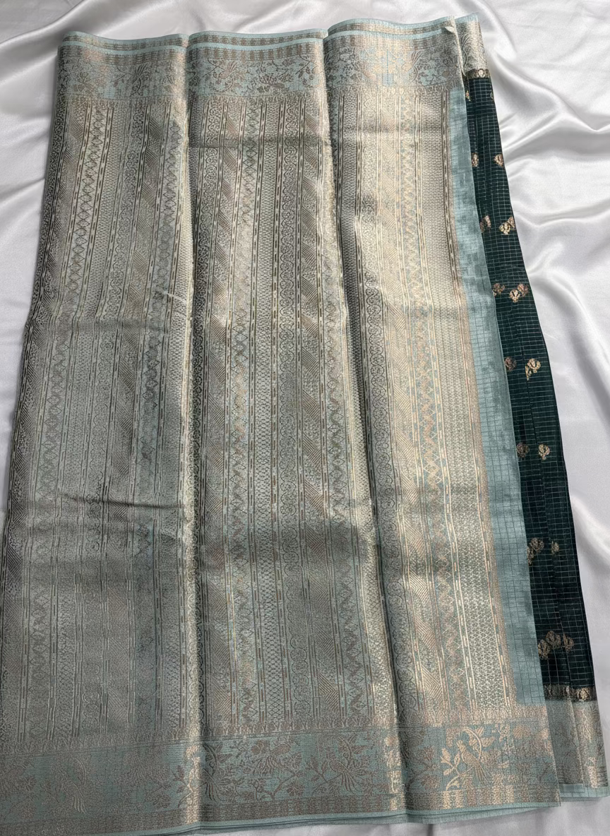 ಕಪ್ಪು ಹಸಿರು ಬಣ್ಣದ ಬನಾರಸಿ ರಷ್ಯನ್ ರೇಷ್ಮೆ ಸೀರೆ, ಚೆಕ್ಕರ್ ಮಾದರಿಯಲ್ಲಿ, ಸಣ್ಣ ಹೂವಿನ ಬುಟ್ಟಾ ಜೊತೆಗೆ ಕಾಂಟ್ರಾಸ್ಟ್ ಬಾರ್ಡರ್ - ಸಾಂಪ್ರದಾಯಿಕ ಉಡುಗೆ.