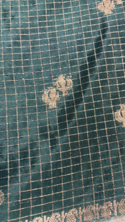 ಕಪ್ಪು ಹಸಿರು ಬಣ್ಣದ ಬನಾರಸಿ ರಷ್ಯನ್ ರೇಷ್ಮೆ ಸೀರೆ, ಚೆಕ್ಕರ್ ಮಾದರಿಯಲ್ಲಿ, ಸಣ್ಣ ಹೂವಿನ ಬುಟ್ಟಾ ಜೊತೆಗೆ ಕಾಂಟ್ರಾಸ್ಟ್ ಬಾರ್ಡರ್ - ಸಾಂಪ್ರದಾಯಿಕ ಉಡುಗೆ.